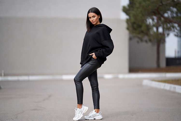 هودی مشکی و لگ چرم با کفش ورزشی سفید